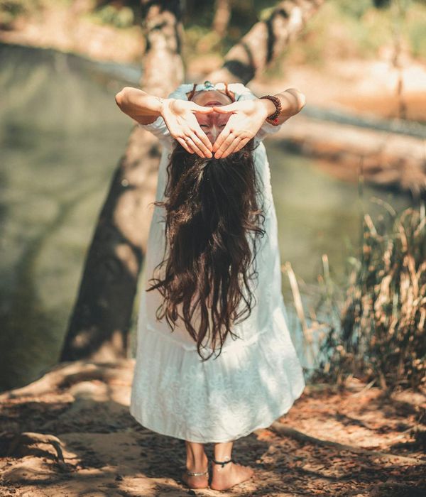 Woman in a peaceful yoga pose in a serene environment.